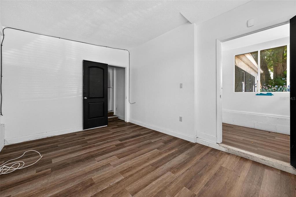 1257 North Pine Hills Road Orlando, FL 32808 - Photo 30 of 35 a view of an empty room with wooden floor and a window