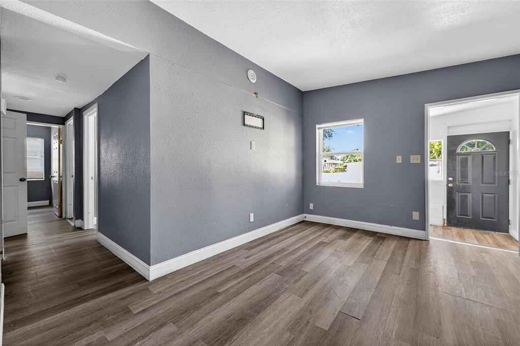 1257 North Pine Hills Road Orlando, FL 32808 - Photo 3 of 35 an empty room with wooden floor and windows