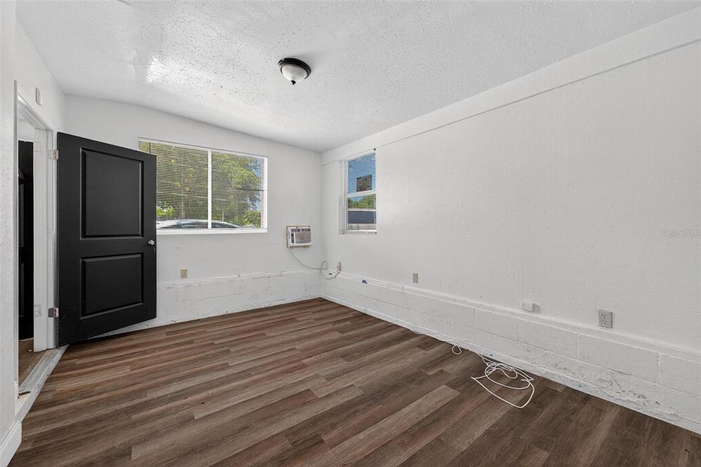 1257 North Pine Hills Road Orlando, FL 32808 - Photo 32 of 35 an empty room with wooden floor cabinet and windows