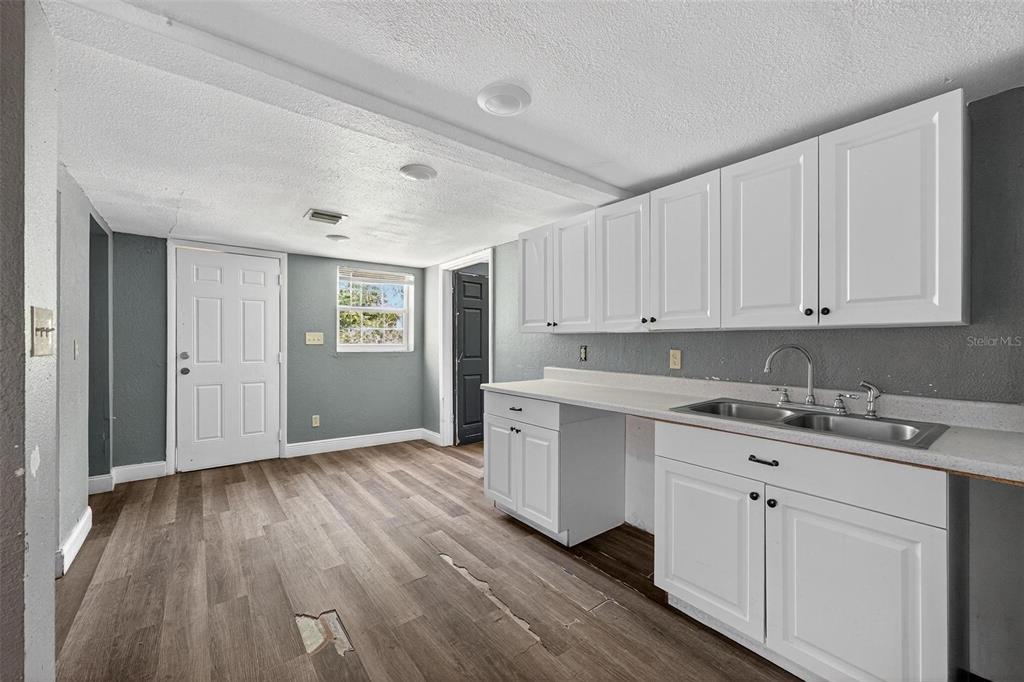 1257 North Pine Hills Road Orlando, FL 32808 - Photo 6 of 35 a view of a kitchen with sink and dishwasher with wooden floor