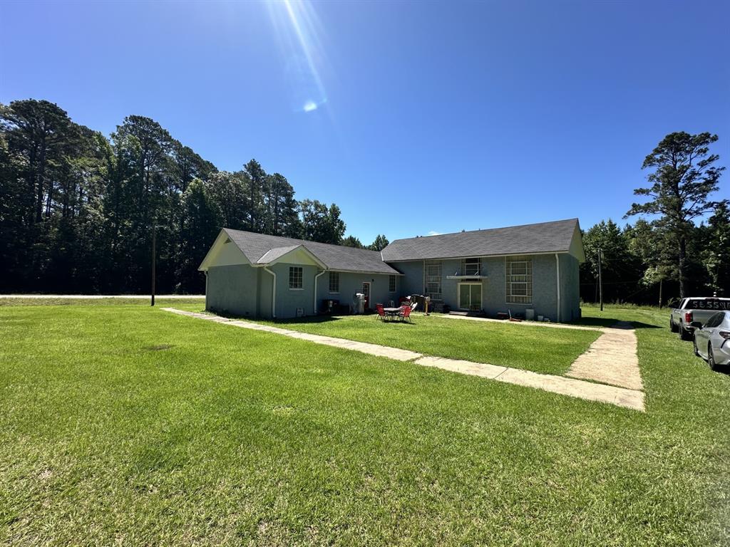 4914 Highway 507 Coushatta, LA 71019 - Photo 4 of 25 a backyard of a house with table and chairs plants and large tree