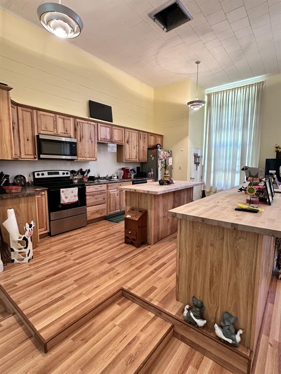 4914 Highway 507 Coushatta, LA 71019 - Photo 8 of 25 a large kitchen with stainless steel appliances wooden floor a stove a sink and a refrigerator