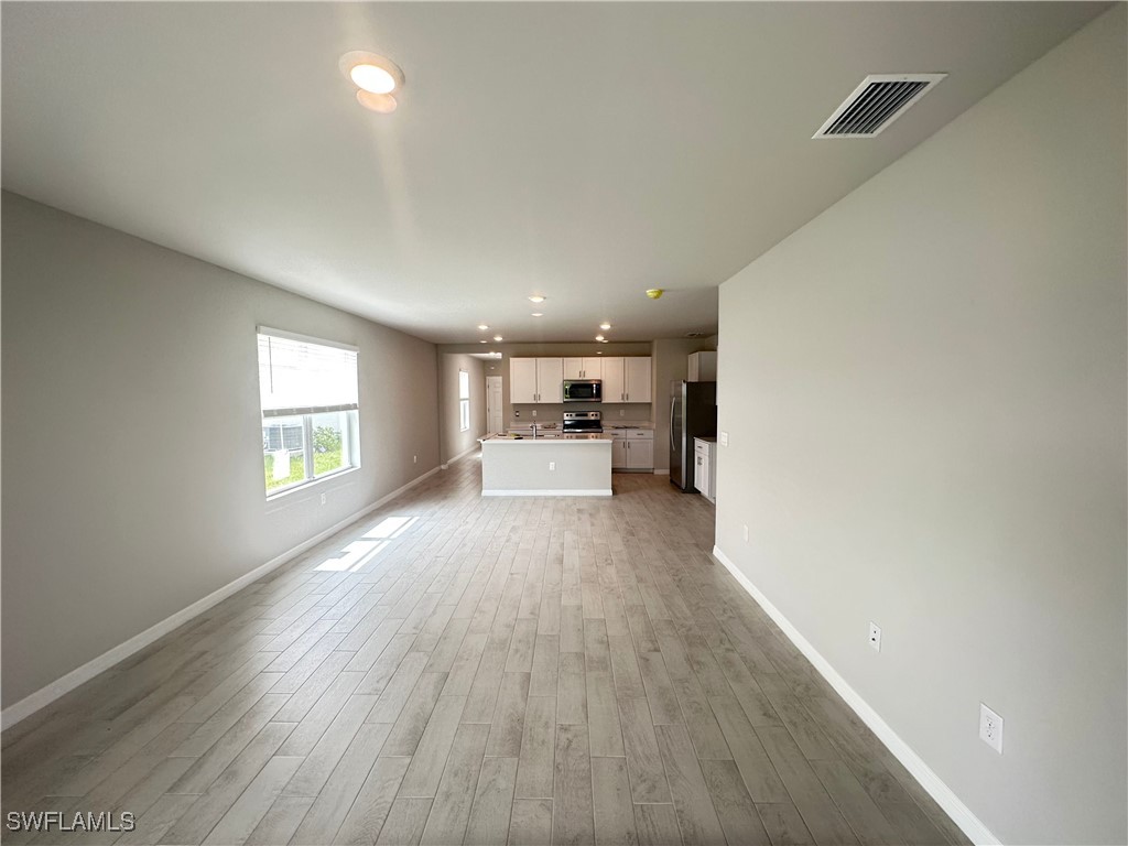 801 Serenity Lane LaBelle, FL 33935 - Photo 2 of 12 a view of a big room with wooden floor a kitchen view and windows