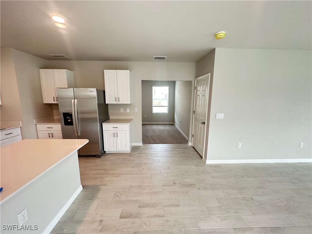 801 Serenity Lane LaBelle, FL 33935 - Photo 3 of 12 a large kitchen with a refrigerator a stove top oven and white cabinets