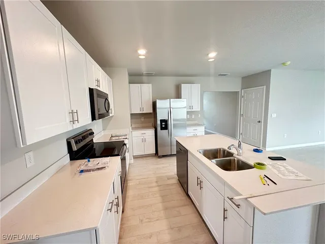 a kitchen with a sink a microwave and cabinets
