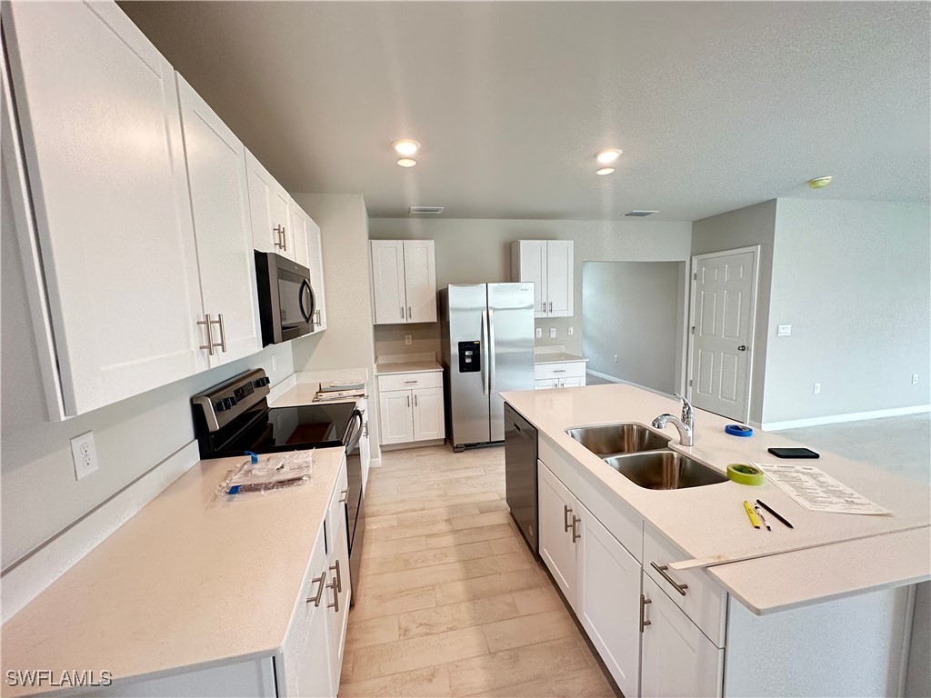 801 Serenity Lane LaBelle, FL 33935 - Photo 4 of 12 a kitchen with a sink a microwave and cabinets