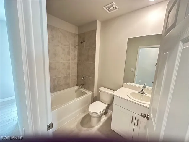 a bathroom with a bathtub shower sink mirror and toilet