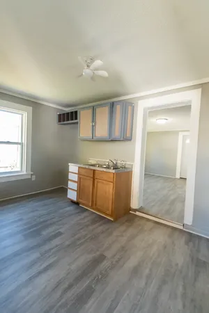 an empty room with wooden floor and window