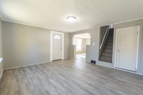 an empty room with wooden floor and stairs