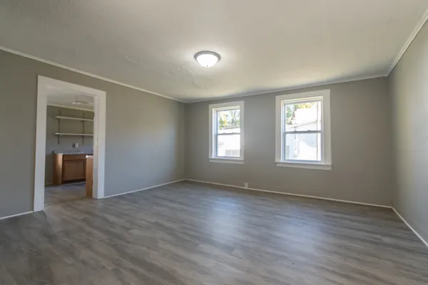 a view of a livingroom with wooden floor and a bathroom
