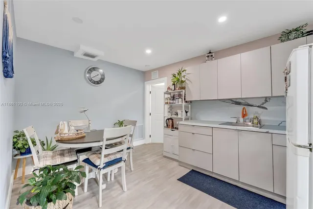 a kitchen with stainless steel appliances kitchen island a table and chairs in it