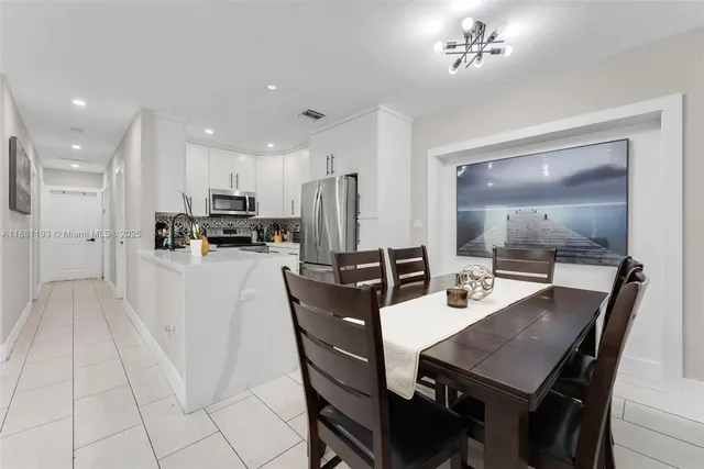 a kitchen with stainless steel appliances white cabinets and a stove top oven