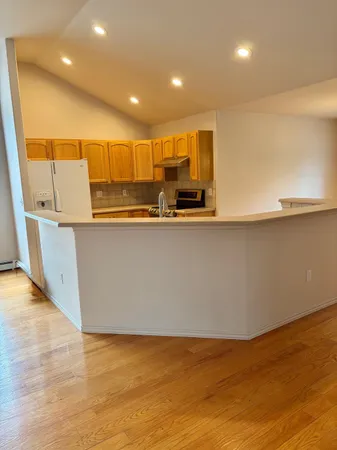 a view of a living room with wooden floor and a sink