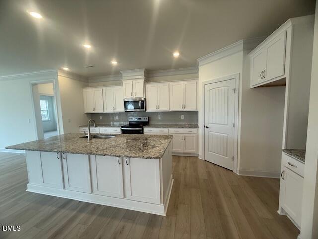 25 Slippery Elm Road Youngsville, NC 27596 - Photo 12 of 36 a kitchen with granite countertop a sink a stove a refrigerator and white cabinets