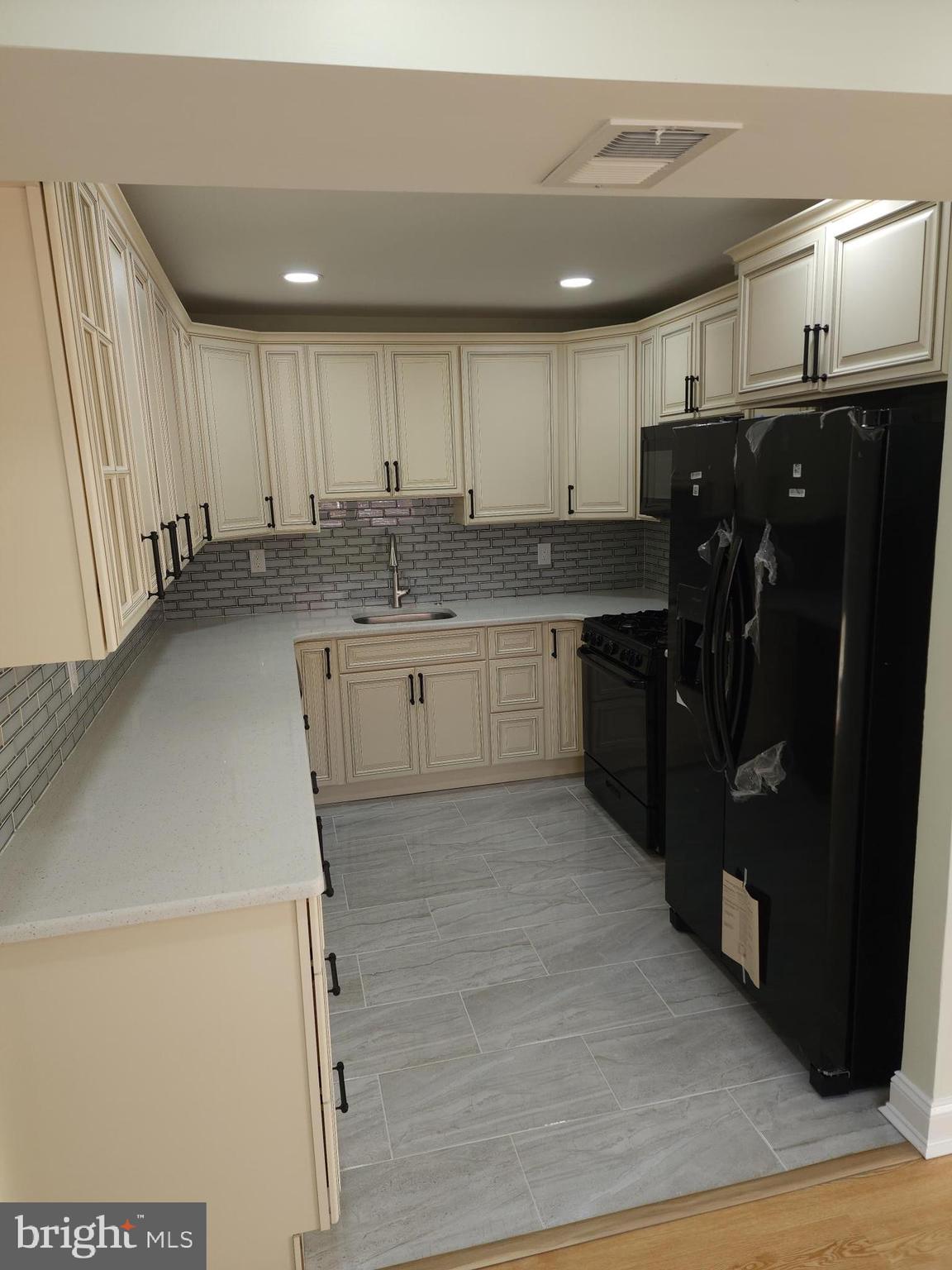 8303 Ridgeway Street Philadelphia, PA 19111 - Photo 6 of 24 a kitchen with kitchen island granite countertop a sink and wooden cabinets