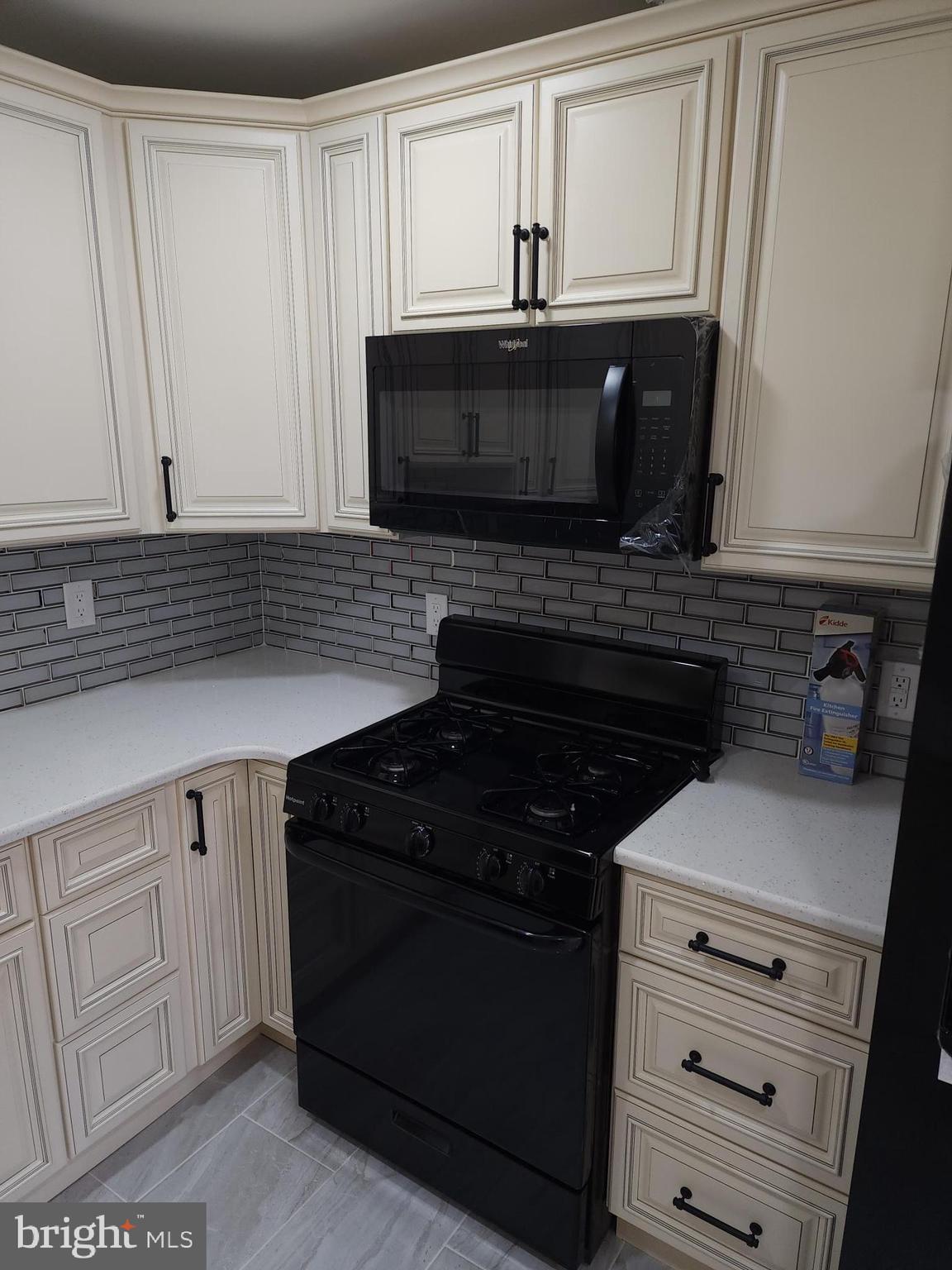 8303 Ridgeway Street Philadelphia, PA 19111 - Photo 7 of 24 a kitchen with white cabinets and black appliances