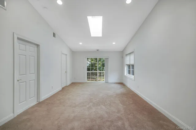 an empty room with windows and cabinet