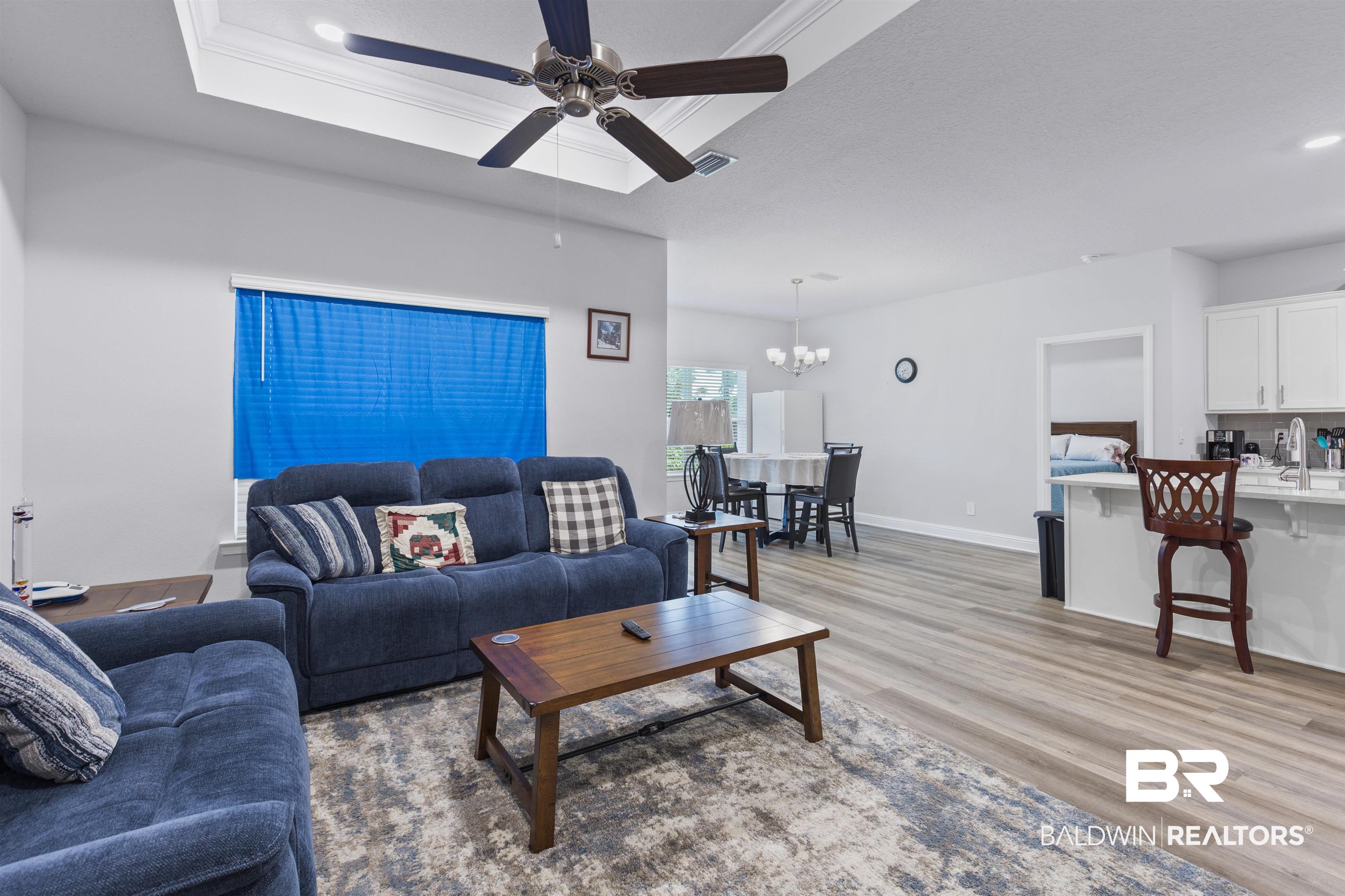 10564 Heirloom Road South Mobile, AL 36608 - Photo 7 of 24 Living room featuring light wood-style floors, recessed lighting, a chandelier, ceiling fan, and a raised ceiling