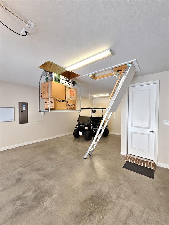 1205 Ivy Charm Way Arlington, TX 76005 - Photo 39 of 40 Garage space featuring a concrete floor, overhead fluorescent lighting, and an attic access ladder