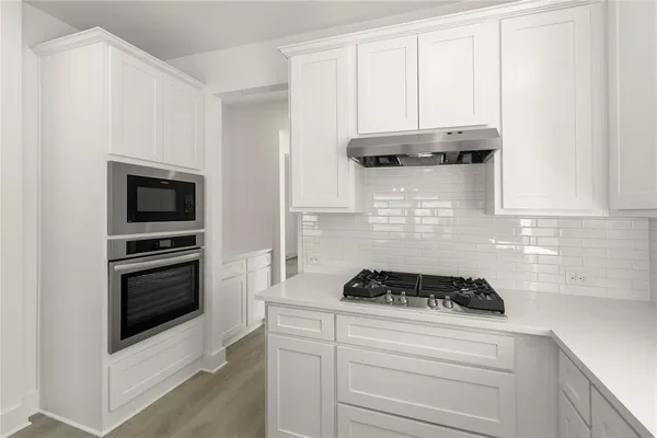 a kitchen with a stove and white cabinets