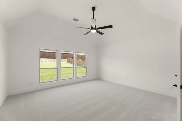 an empty room with windows and ceiling fan