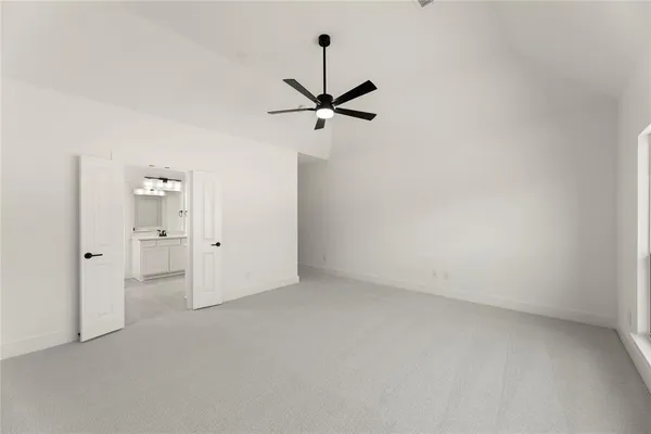 an empty room with fan and windows