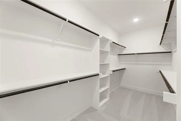 a view of walk in closet with empty racks