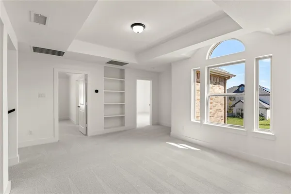 a view of an empty room with a window and closet area