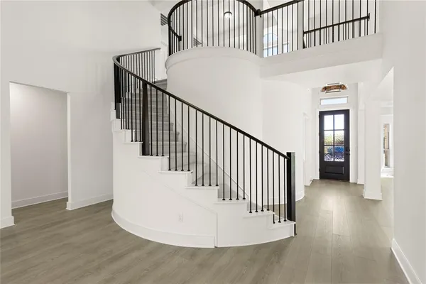 a view of staircase with railing and white walls