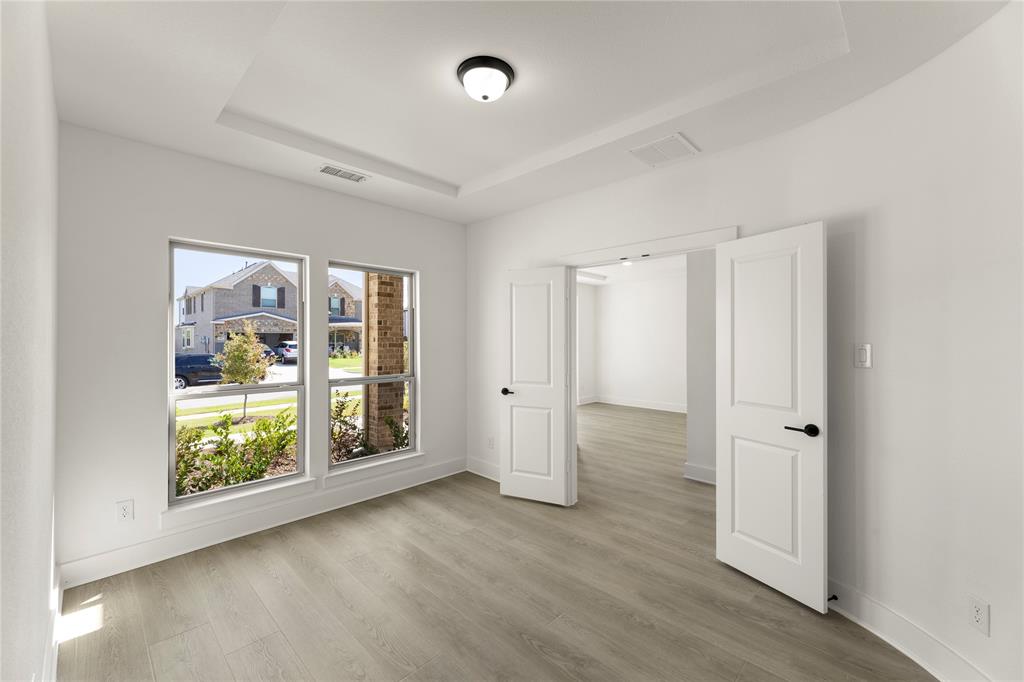 968 Gold Finch Lane Forney, TX 75126 - Photo 7 of 27 a view of an empty room with wooden floor and a window