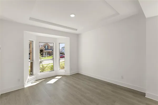an empty room with wooden floor and door
