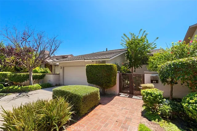 a front view of a house with garden and plants