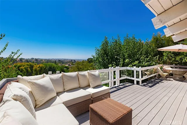 a view of a patio with couches a table and chairs under an umbrella