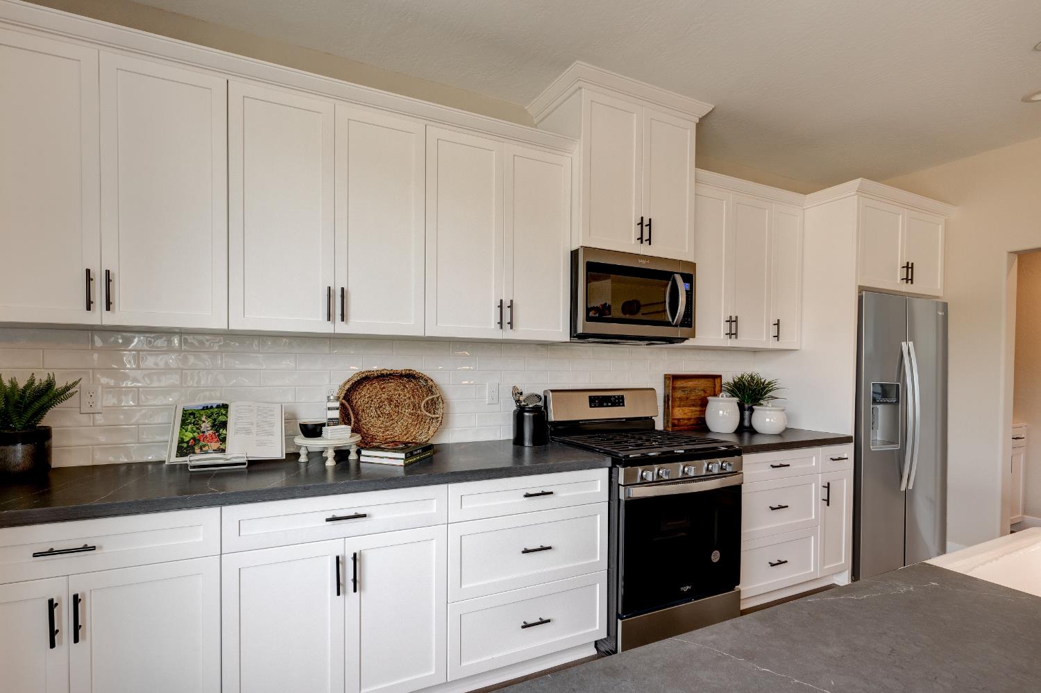 1179 Maclure Avenue Madera, CA 93636 - Photo 12 of 36 a kitchen with white cabinets and black appliances