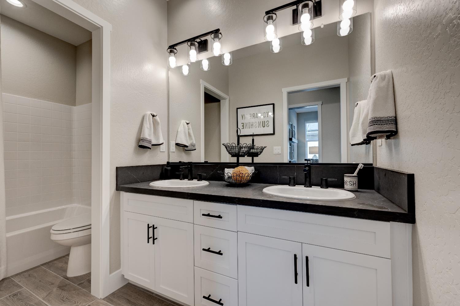 1179 Maclure Avenue Madera, CA 93636 - Photo 8 of 36 a bathroom with a sink a toilet and a mirror