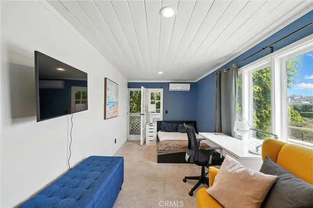 a bedroom with furniture and large windows