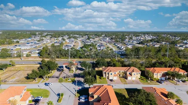 an aerial view of a city with lots of residential buildings ocean and mountain view in back