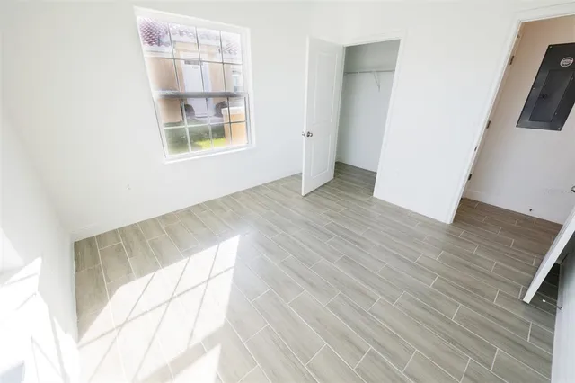 an empty room with wooden floor and windows