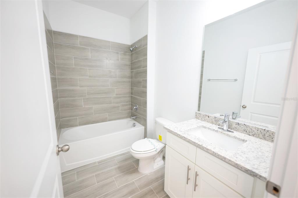 1736 Pacific Road Kissimmee, FL 34759 - Photo 7 of 42 a bathroom with a granite countertop sink a toilet and shower