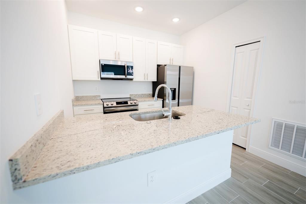 1736 Pacific Road Kissimmee, FL 34759 - Photo 8 of 42 a kitchen with stainless steel appliances granite countertop a sink a stove and a refrigerator
