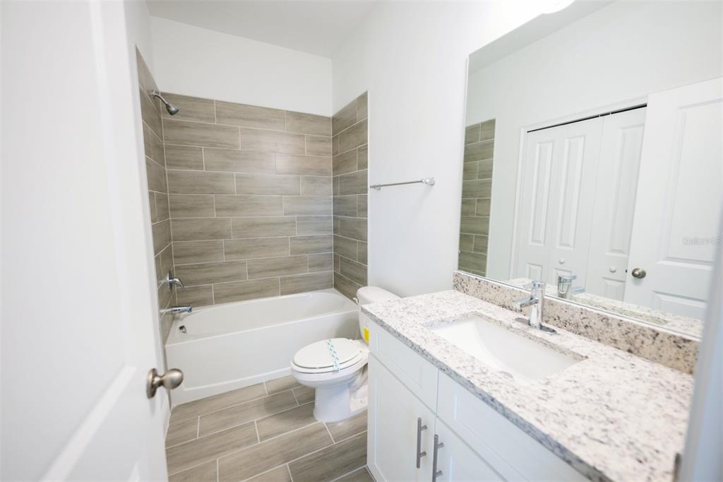 1736 Pacific Road Kissimmee, FL 34759 - Photo 9 of 42 a bathroom with a granite countertop sink a toilet and shower