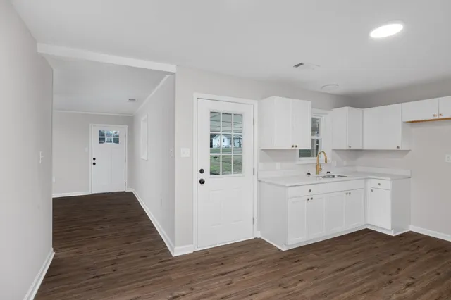 a kitchen with wooden floors and white appliances