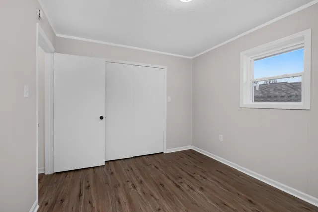 a view of a room with wooden floor and window