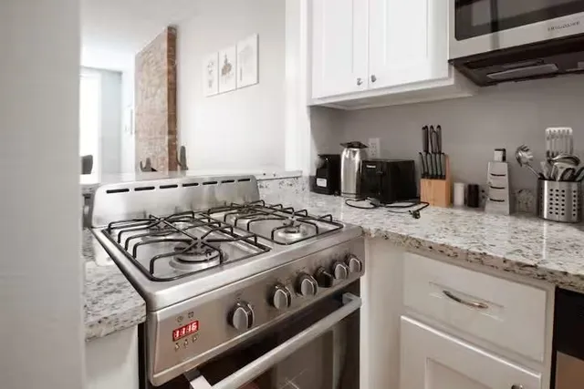 a white stove top oven sitting inside of a kitchen