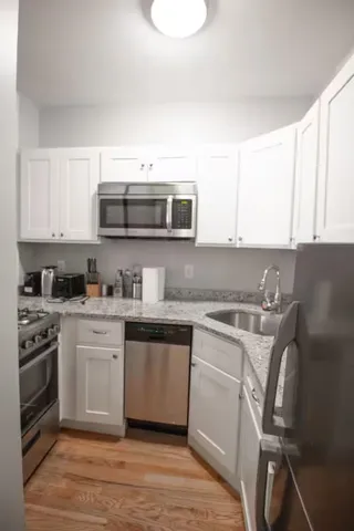 a kitchen with stainless steel appliances granite countertop a stove a sink and a microwave