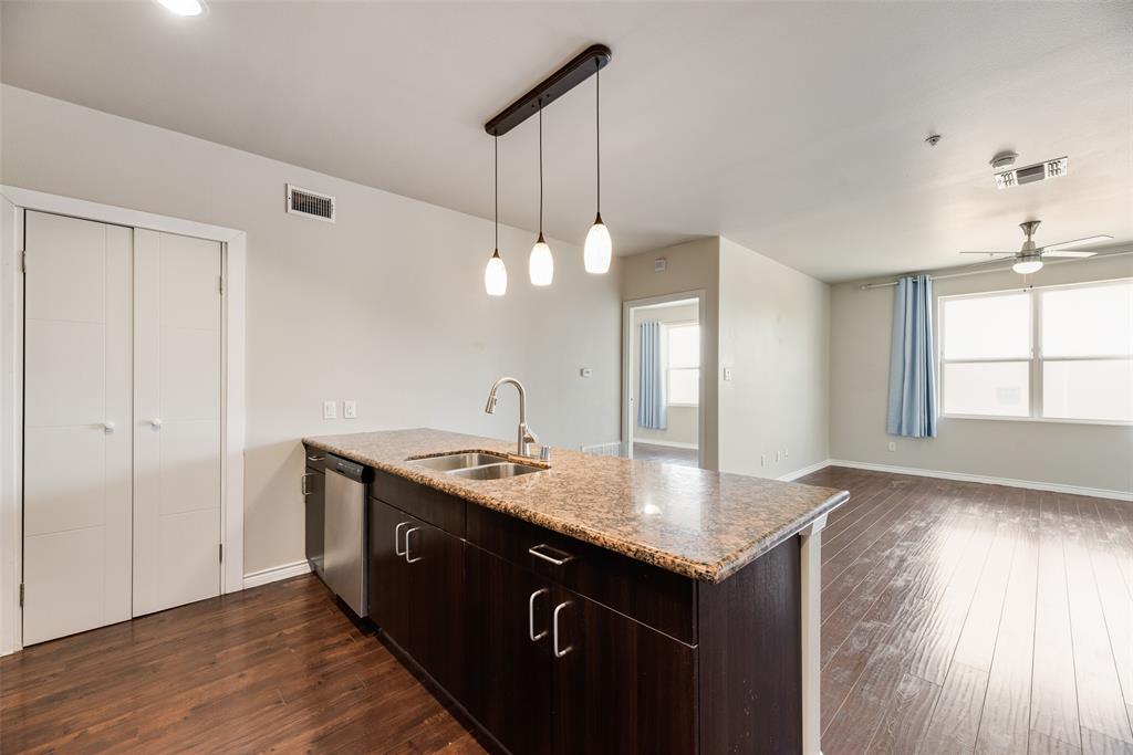 1100 West Trinity Mills Road, Unit 2040 Carrollton, TX 75006 - Photo 2 of 21 a kitchen with a sink cabinets and wooden floor