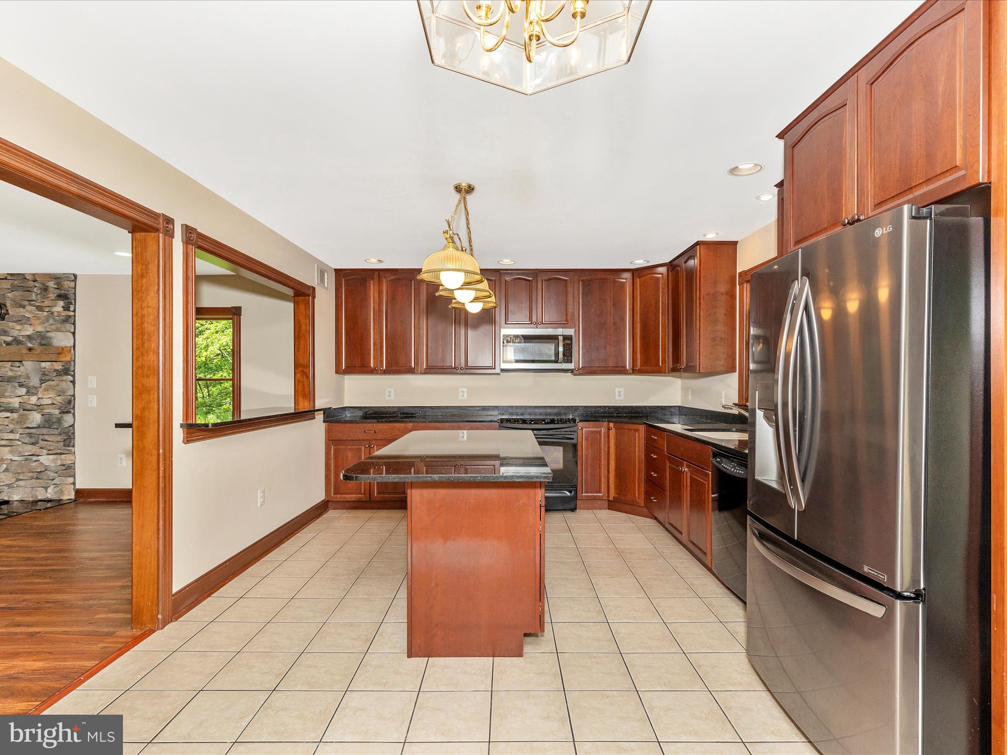 10433 Grindstone Run Road Myersville, MD 21773 - Photo 18 of 42 a kitchen with stainless steel appliances granite countertop a refrigerator a sink and a stove