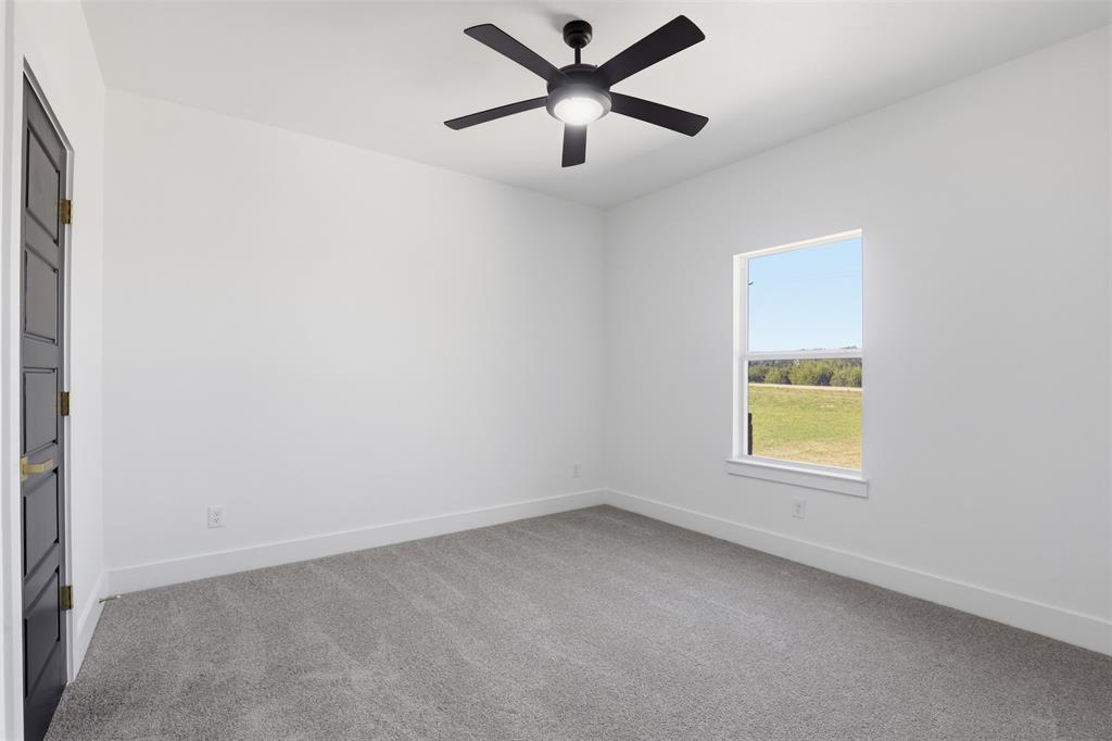 6657 Buffalo Ridge Circle Godley, TX 76044 - Photo 18 of 31 an empty room with a window and a ceiling fan