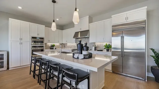 a kitchen with kitchen island granite countertop a center island a refrigerator a stove a kitchen island with a stove and refrigerator