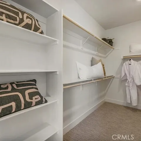 a view of walk in closet with clothes and shoes